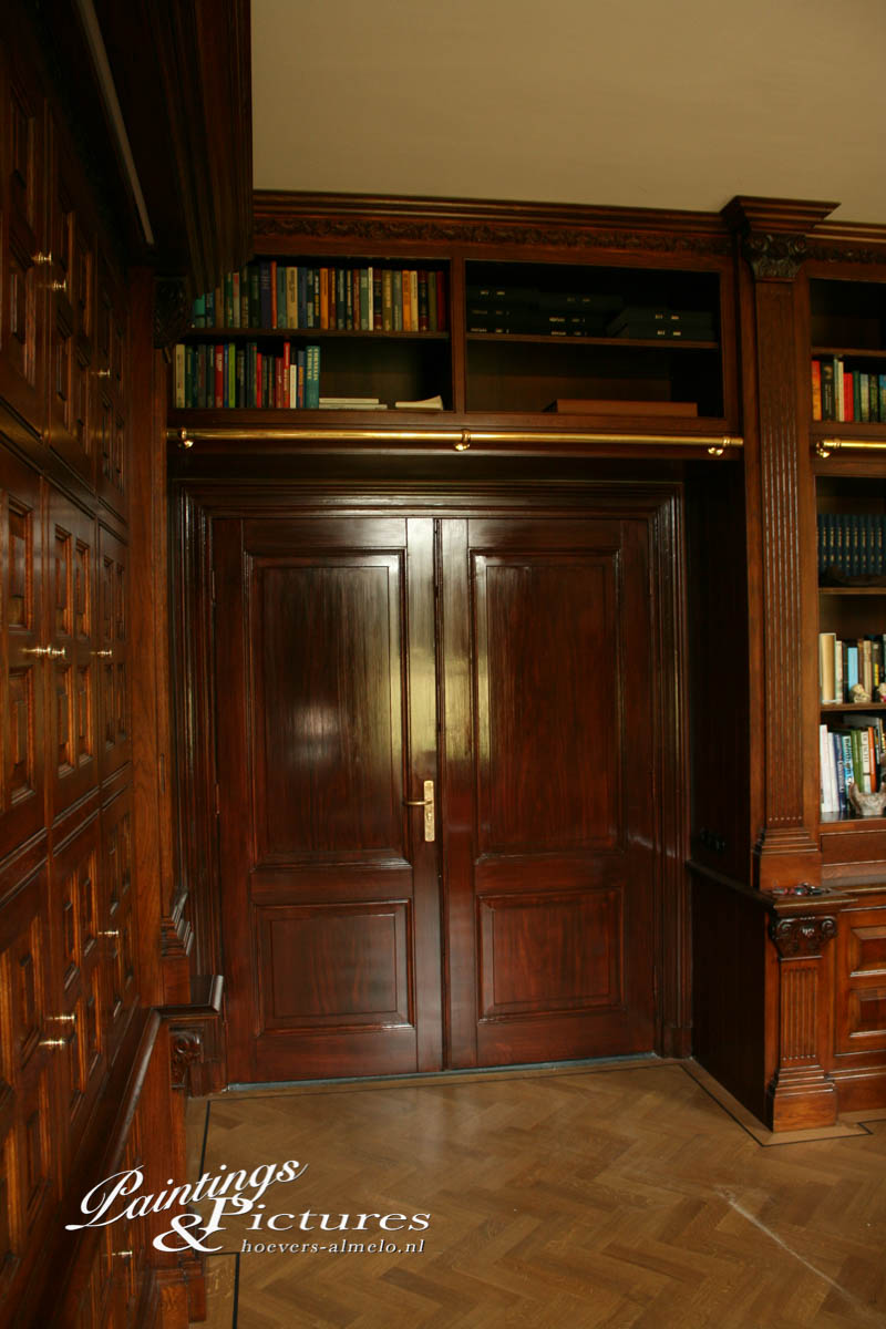 Witte doorloopdeur aangepast aan de handgemaakte boekenkast en kantoor. 